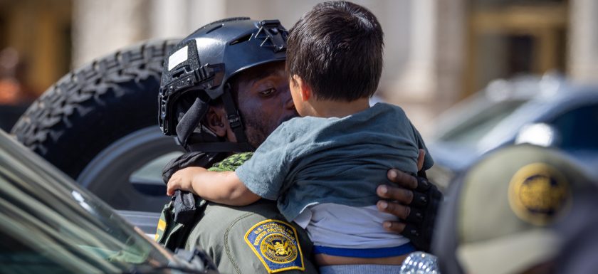 An Ice agent holding a toddler
